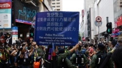 香港警察對在中國國慶日要求北京政府釋放12港人的抗議者展示警示牌。（2020年10月1日）