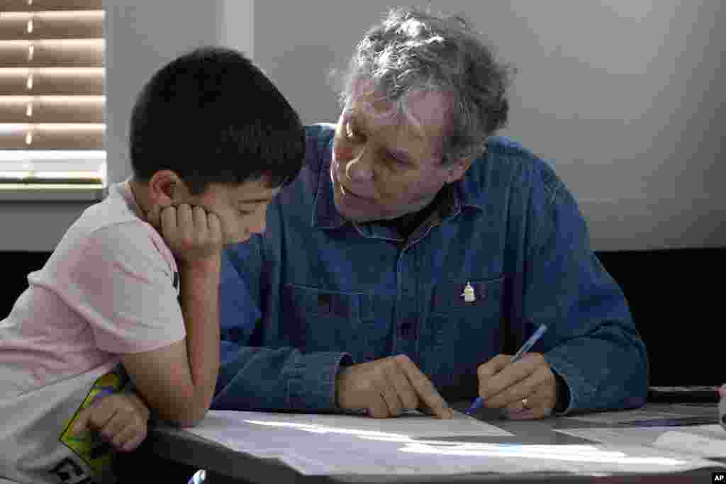 Sen. Sherrod Brown, D-Ohio, fills out his ballot with his grandson, Milo Molina, left, 8, Nov. 5, 2024, in Cleveland.