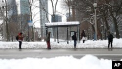 Građani Čikaga čekaju autobus na aveniji Nort Mičigen, 16. februara 2021. (Foto: AP)