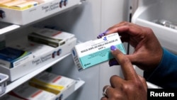 FILE - A doctor points to a measles, mumps and rubella vaccine — also known as an MMR vaccine — during a measles outbreak in Lubbock, Texas, March 6, 2025. 