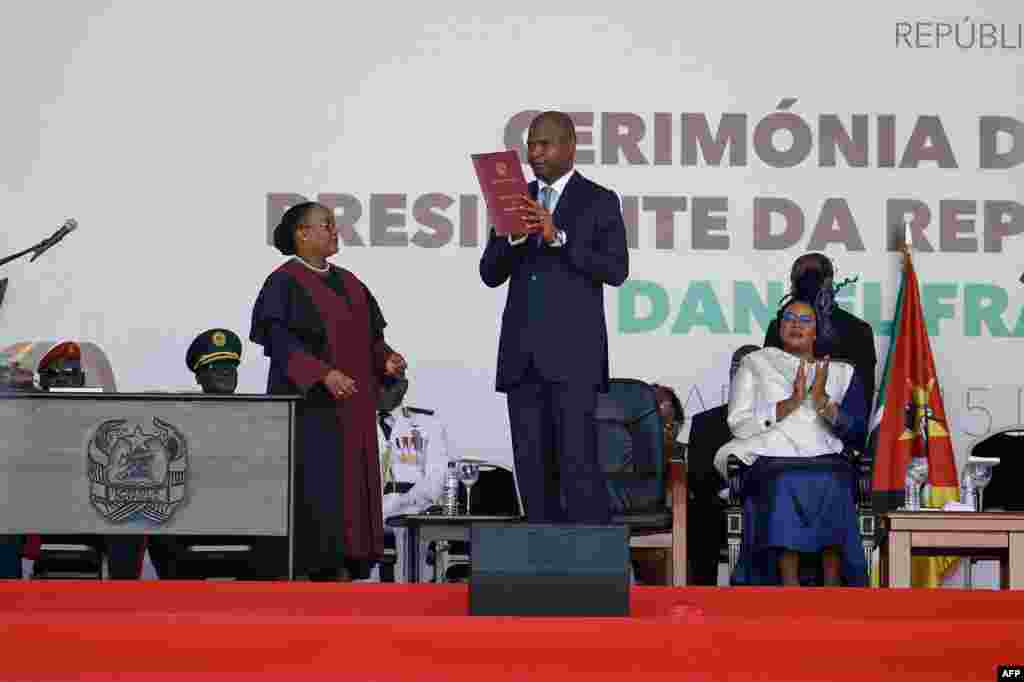Daniel Chapo segura a constituição de Moçambique durante o juramento de posse como Presidente de Moçambique, em Maputo, a 15 de janeiro de 2025.