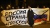 UKRAINE – Ukrainian protesters hold a banner reading ""Russia is an aggressor country" during a rally in Mariupol, on the south coast of the Azov Sea, eastern Ukraine, on November 28, 2018.