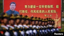 資料照：解放軍士兵列隊在中國領導人習近平畫像前走過。 （2015年8月22日） 