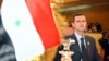 FILE - Syrian President Bashar Assad looks on at his country's flag at the opening of the 16th ordinary session of Arab Summit in Tunis, Tunisia, May 22, 2004. 
