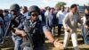 FILE - Members of a security team escort Lesotho politician Thomas Thabane (center, in background) after he cast his vote during the country's national elections in Magkhoakhoeng village, outside the capital Maseru, Feb. 28, 2015. Thabane's estranged wife, Lipolelo Thabane, was shot dead Thursday by unknown assailants. 