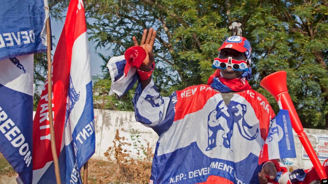 FILE - A supporter of the New Patriotic Party (NPP) wears campaign paraphernalia on the side of a road in Accra, Ghana, Nov. 23, 2012. The NPP has said it will challenge the ruling National Democratic Congress party with its own manifesto October 18.