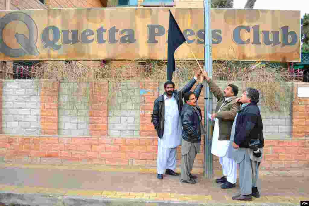 Journalists hold a black flag outside the Quetta Press Club to mourn the three journalists killed in the January 10th explosions in the city, Quetta, Pakistan, January 11, 2013.