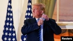 Arhiva - Predsednik SAD Donald Tramp skida zaštitnu medicinsku masku, dok pozira na Trumanovom balkonu u Beloj kući, Vašington.