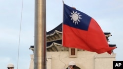 兩名台灣衛兵在台北中正紀念堂自由廣場舉行的每日昇旗典禮上降下國旗。 (美聯社：2023年10月10日)