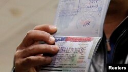 FILE - A foreign national shows a canceled U.S. visa in his passport, having been denied entry, at Washington Dulles International Airport in Chantilly, Virginia, Feb. 6, 2017. 