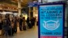FILE - A sign asking people to wear face coverings to curb the spread of coronavirus is displayed at London St Pancras International rail station, in London, the Eurostar hub to travel to European countries, Dec. 17, 2021. 