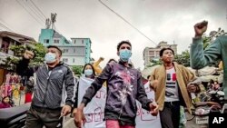 FILE - Protesters march through the streets during an anti-government demonstration in Mandalay, Myanmar, Dec. 7, 2021.