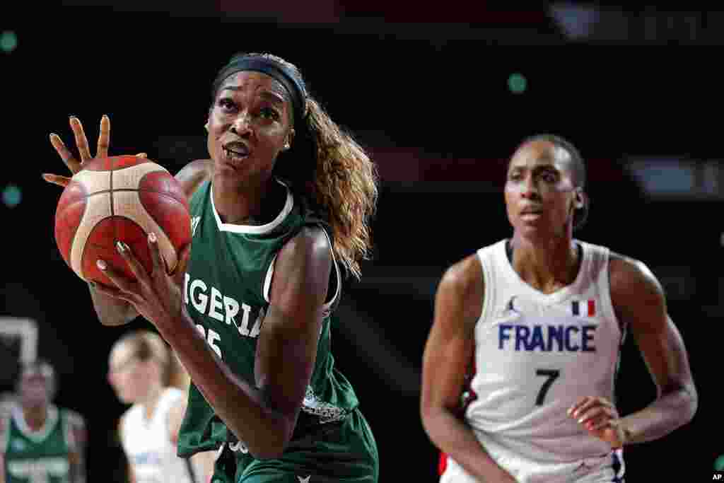 Nigeria's Victoria Macaulay, drives past France's Sandrine Gruda (7) during a women's basketball preliminary round game at the 2020 Summer Olympics, Friday, July 30, 2021, in Saitama, Japan. (AP Photo/Charlie Neibergall)