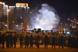 Police block a street and use smoke grenades during a protest after the Belarusian presidential election, in Minsk, Belarus, Aug. 9, 2020.