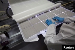 A production operator checks a panel at the SolarWorld solar panel factory in Hillsboro, Oregon, Jan. 15, 2018.