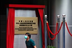 一名男子走過香港一家酒店外北京新設的駐港國安公署的牌子。（2020年7月8日）