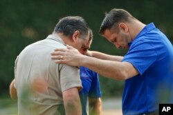 Kapetan policije okruga Ventura, sveštenici i aktivisti pružaju podršku jedni drugima blizu mesta masakra u Tauzend Ouksu u Kaliforniji.
