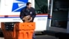 FILE - A U.S. Postal Service employee loads parcels outside a post office in Wheeling, Ill., Jan. 29, 2024. 