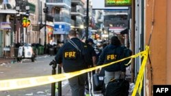 FBI investigators arrive at the scene where the white Ford F-150 pickup truck that crashed into a work lift after allegedly driving into a crowd of New Year's revelers in the French Quarter of New Orleans, Louisiana, on January 1, 2025.