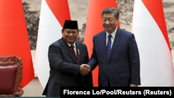 Presiden China Xi Jinping dan Presiden Prabowo Subianto berjabat tangan selama upacara penandatanganan kerja sama di Balai Agung Rakyat di Beijing, China, 9 November 2024. (Foto: Florence Lo/Pool/Reuters)