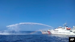 Sebuah kapal Penjaga Pantai China, kanan, menggunakan meriam airnya pada kapal Biro Perikanan dan Sumber Daya Perairan Filipina (BFAR), saat mendekati Scarborough Shoal di Laut China Selatan yang disengketakan, 9 Desember 2023 (Foto: Penjaga Pantai Filipina).