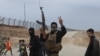 A Syrian Kurdish fighter flashes the V-sign for victory as local gunmen control the area around Qamishli's airport in northeastern Syria on Dec. 8, 2024