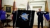 Šef Svemirskih operacija u Svemirskim snagama SAD, general Džon Rajmond, u centru, drži zastavu Svemirskih snaga SAD u Ovalnom kabinetu u Beloj kući, 15. maja 2020.
