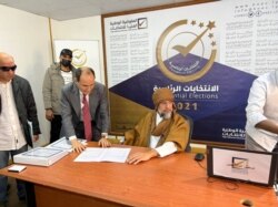 FILE - Saif al-Islam al-Gadhafi, son of Libya's former leader Moammar Gadhafi, registers as a presidential candidate for the December 24 election, at the registration center in the southern town of Sebha, Nov. 14, 2021.
