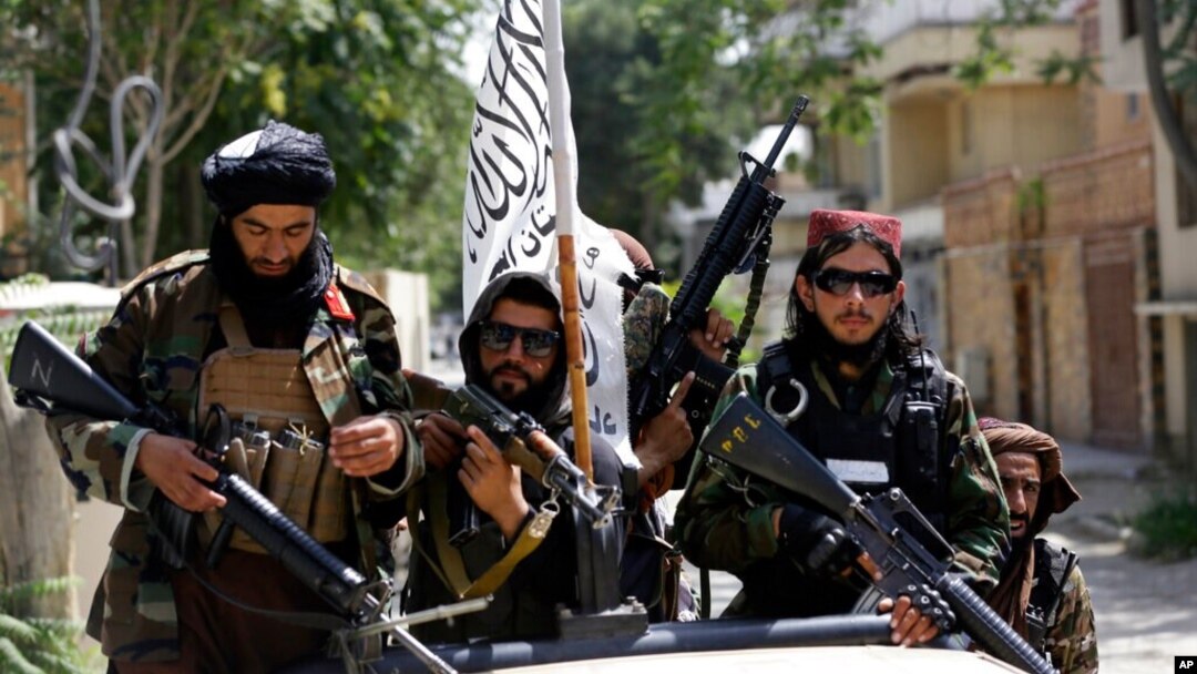 FILE - Taliban fighters display their flag on patrol in Kabul, Afghanistan, Aug. 19, 2021.