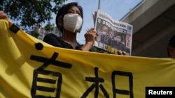 在西九龍法院的一次聽證期間，一名支持者舉著報紙在法院外聲援《蘋果日報》。(2021年6月19日)