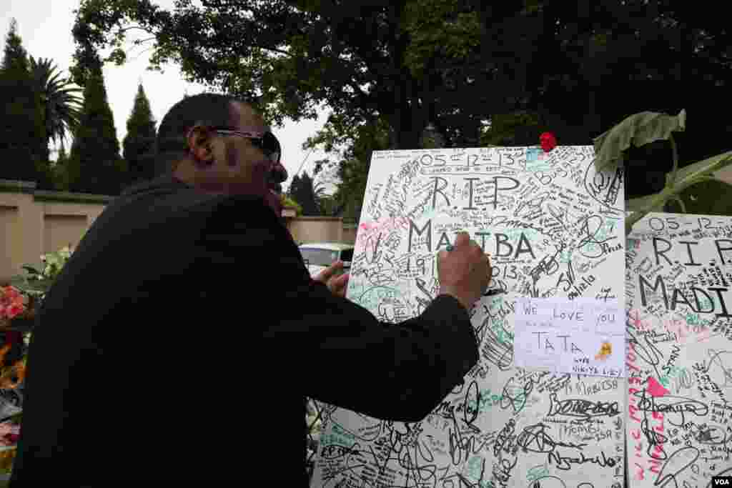 Fãs de Mandela deixam tributo à porta da sua antiga casa em Houghton, África do Sul. (Hannah McNeish para VOA)