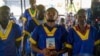 FILE - Marcel Malanga holds the Bible as he attends a trial where he is accused with others of a failed coup attempt, at Kinshasa's Ndolo prison in Kinshasa on Sept. 13, 2024.