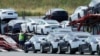 FILE - Tesla cars are loaded onto carriers at the Tesla electric car plant in Fremont, California, May 13, 2020. The Biden adminstration has made short-term emission reductions a top priority. 