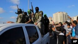Palestinci pozdravljaju pripadnike al-Kasam brigade Hamasa u Gazi, arhivska fotografija iz juna 2015.. (Foto: AP/Adel Hana)
