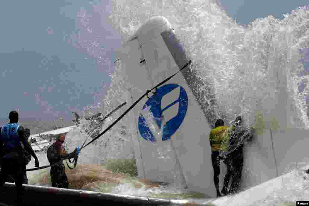 French soldiers and rescuers prepare to pull the remains of a cargo plane that crashed in the sea near the Felix Houphouet Boigny International Airport, in Abidjan, Ivory Coast, Oct. 14, 2017.