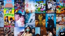 Visitors walk past a display of posters for Chinese movie and television productions at the China International Fair for Trade in Services in Beijing, Sept. 3, 2021. 