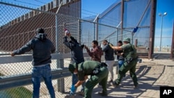 Anggota penjaga perbatasan memeriksa sejumlah migran saat mereka memasuki area El Paso, Texas, dari Ciudad Juarez, Meksiko, pada 10 Mei 2023. (Foto: AP/Andres Leighton)