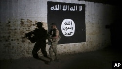 Arhiva, ilustracija - Irački vojnik istražuje tunel ispred grafita sa zastavom terorističke grupe Islamska država.