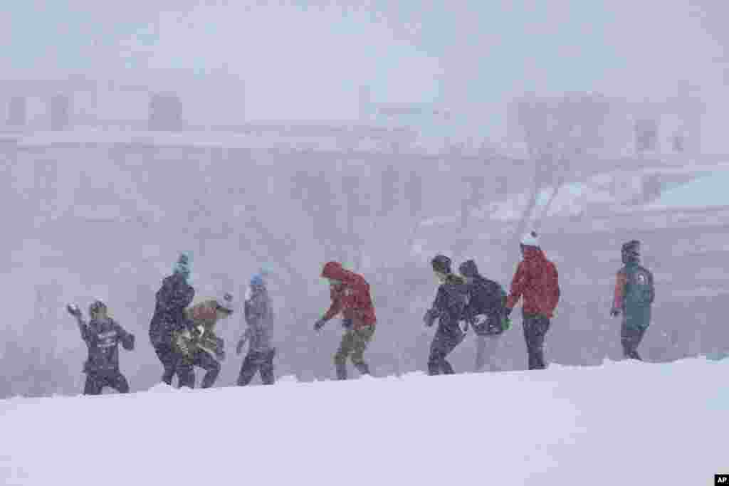 Pessoas envolvem-se numa luta de bolas de neve durante uma tempestade de neve em Washington, a 6 de janeiro de 2025.