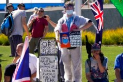 Demonstran anti-vaksinasi berdemonstrasi di luar Melbourne Park setelah Novak Djokovic diyakini ditahan di sebuah hotel detensi imigrasi di Melbourne, Australia, 15 Januari 2022. (Foto: AP)