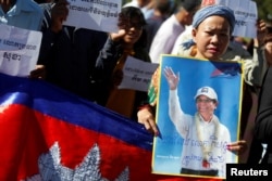 FILE - Supporters of Kem Sokha, leader of the Cambodia National Rescue Party, stand outside the Appeal Court during a bail hearing for the jailed opposition leader in Phnom Penh, Cambodia Sept. 26, 2017.