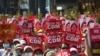 Anti-coup protesters hold up signs calling on others to join the CDM (Civil Disobedience Movement) during a rally near the Mandalay Railway Station in Mandalay, Myanmar, Feb. 22, 2021.