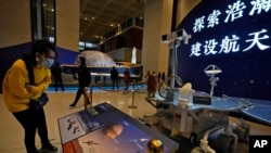 2021年3月12日，一名參觀者在北京觀看中國天問一號飛船火星探測器複製品的展覽。（美聯社照片）
