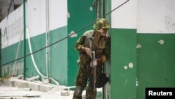 FILE - A Kenyan police officer stands outside the General Hospital during a joint operation with Haitian police, in Port-au-Prince, Haiti, July 29, 2024. Gang members set fire to the hospital on Feb. 13, 2025.