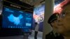 FILE - Visitors look at a display of information technologies at an exhibition highlighting China's achievements under President Xi Jinping's leadership, at the Beijing Exhibition Hall in Beijing, China, Oct. 17, 2017.