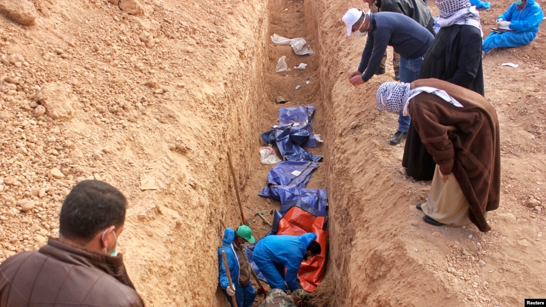 FILE - Men excavate remains of more than 25 men reportedly killed by Islamic State fighters on the outskirts of Saadia in Iraq's Diyala province, Jan. 15, 2015. 