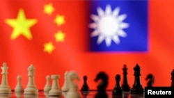 這張圖片攝於2023年4月11日，國際象棋子在展示的中國和台灣國旗前。