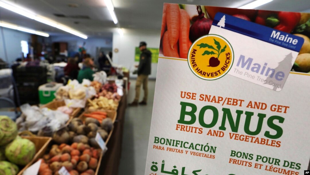 FILE - A sign advertises food stamp-related services at a farmer's market in Topsham, Maine, March 17, 2017.