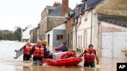 Rescue workers pull residents on a small boat after storm Herminia has unleashed downpours on the region, Jan. 27, 2025 in in the village of Guipry Messac, western France.