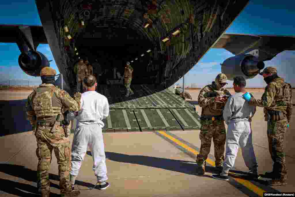 The first U.S. military aircraft to carry detained migrants whom U.S. Department of Homeland Security spokesperson Tricia McLaughlin called "highly dangerous criminal aliens", to a detention facility at Guantanamo Bay, is boarded from an unspecified location in the U.S., Feb. 4, 2025 